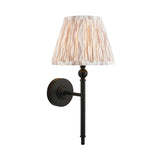 Endon Caldmere wall light with a tapered pleated beige Ikat fabric shade on slim matt black metalwork, shown against a plain white background.