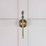 Caldmere Ikat wall light in antique brass with slim adjustable arm and B22 lamp holder, shown without shade against a light panelled wall.