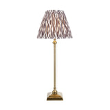 Endon Caldmere table lamp with slim antique brass candlestick base and pleated grey Ikat print fabric shade, shown on a plain white background.