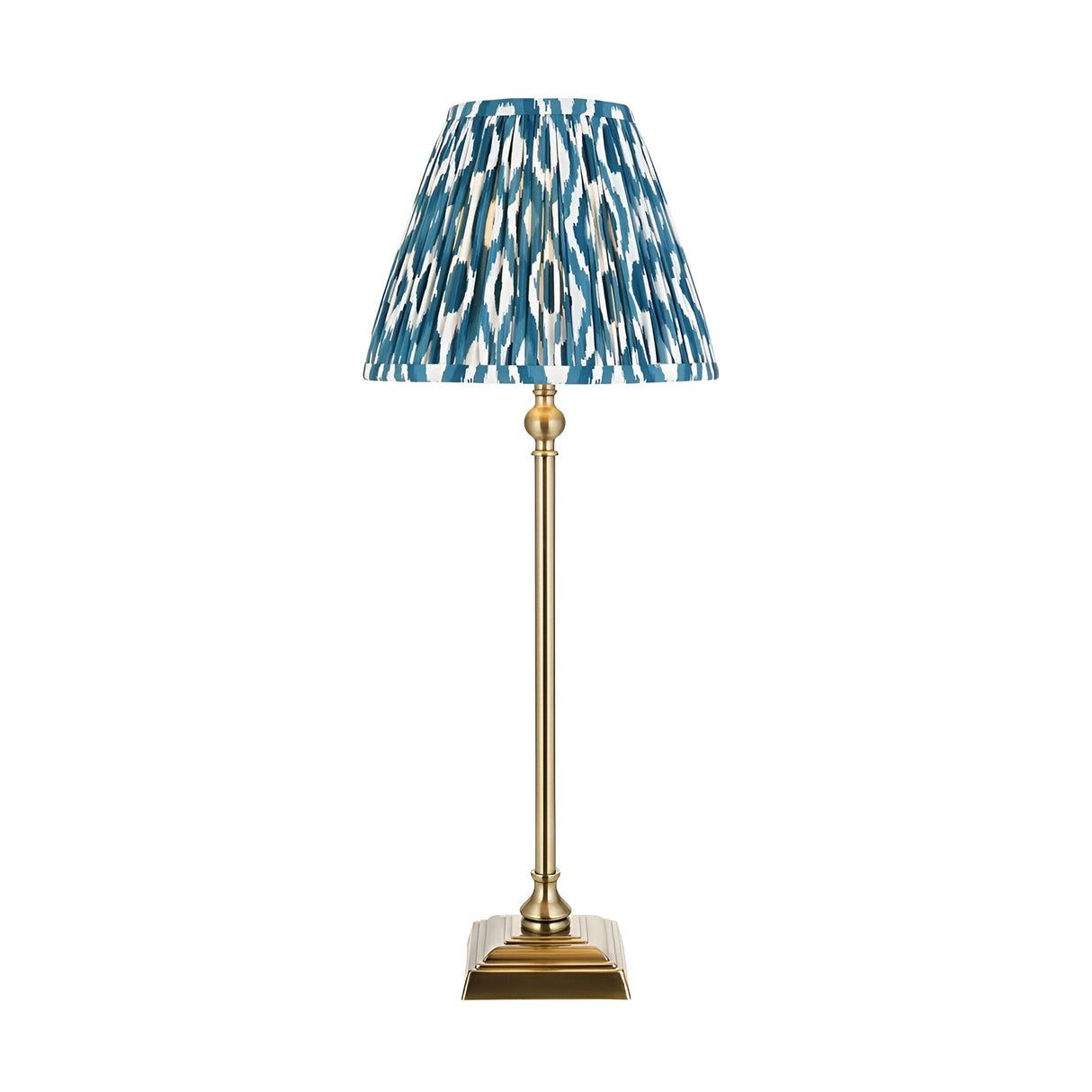 Endon Caldmere table lamp with slim antique brass candlestick stand and pleated blue ikat-print fabric shade, shown on a plain white background.