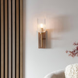 Bramton Wall Light in brass with ribbed curved glass shade on grooved walnut-stained wood backplate, mounted beside a wooden slatted panel.