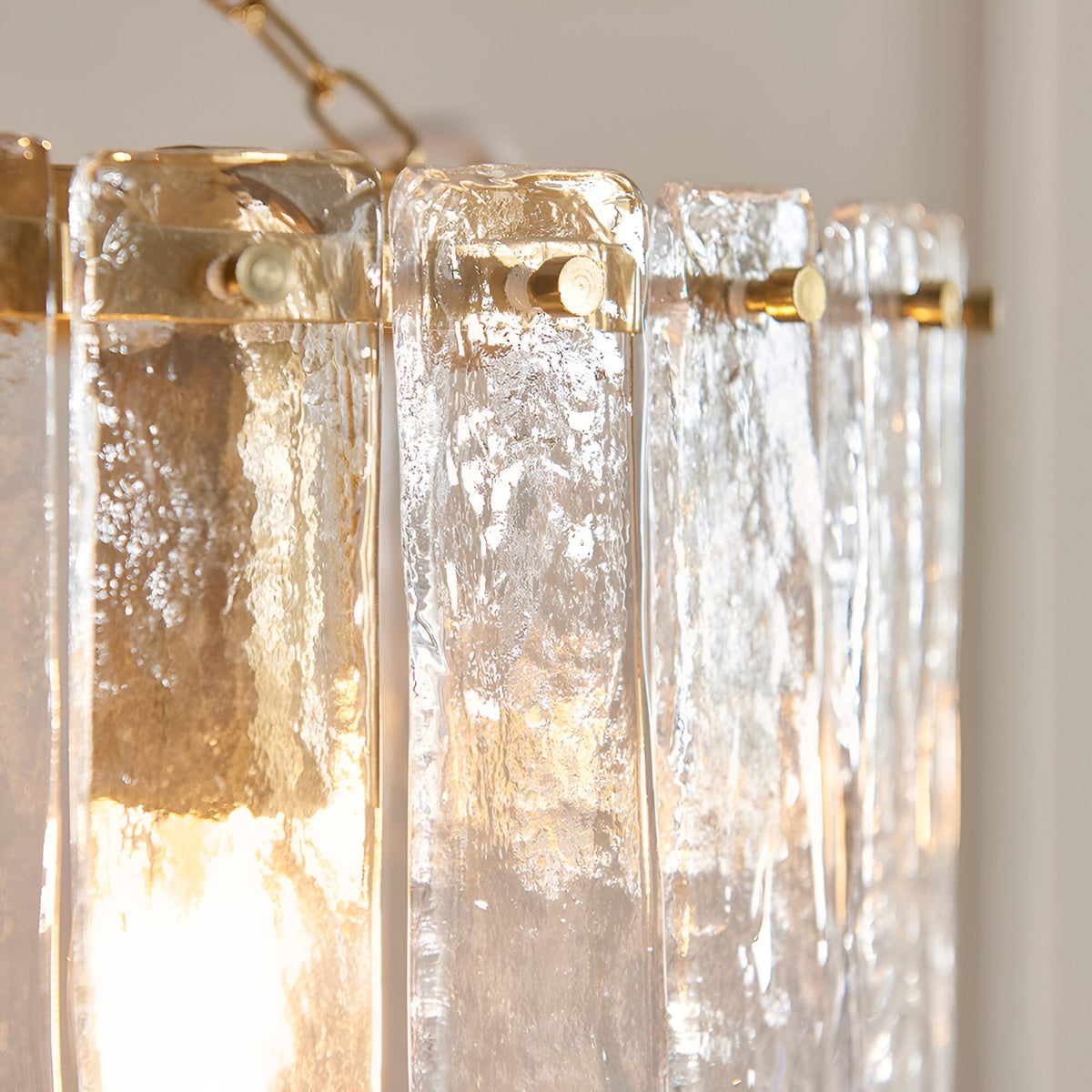 Close-up of the Brockhurst 3 Light Pendant, showing clear handmade textured glass panels ringed by a brass band with visible fixing screws.