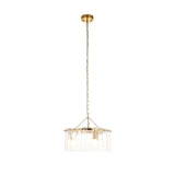 Brockhurst 3 Light Pendant in Brass with a circular drum of clear textured glass panels, suspended from a chain and ceiling rose on a plain white background.