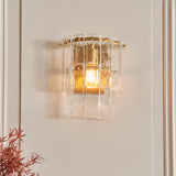 Brockhurst Wall Light in brass, single-light fixture with layered textured glass panels lit warm against a plain wall in a hallway setting.