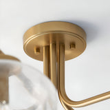 Close-up of the Endon Pemberton semi-flush ceiling light's brushed brass ceiling plate and curved arms, with a glass shade visible below.