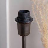 Close-up of the Endon Chartworth table lamp's bronze stepped stem and E14 shade ring fitting, shown beside dried pampas against a light wall.