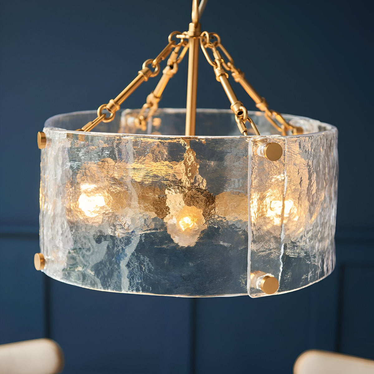 Brockmont 4-Light Pendant in brass with a cylindrical rippled glass shade, visible bulbs, brass fixings, and chain suspension.