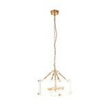 Brockmont 4 Light Pendant in brass with a cylindrical shade of ribbed, textured glass panels, hung from an adjustable chain on a plain white background.