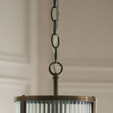 Close-up of Endon Rothbury Pendant in antique brass, showing chain suspension and top of ribbed clear glass cylindrical shade.