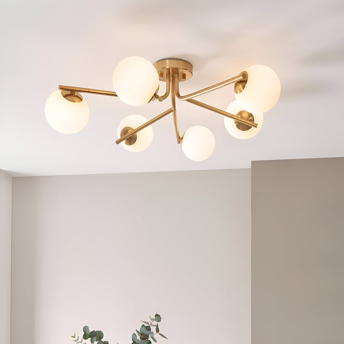 Grantham 6 Light Semi-Flush Ceiling Light in aged brass with six branching arms and round opal glass globe shades, shown illuminated on a light ceiling.