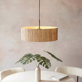 Endon Salcombe 3 light pendant with a woven natural seagrass drum shade and matt black cable, hung above a dining table with a monstera in a vase.