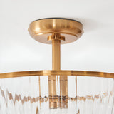 Close-up of the Endon Langton flush uplighter's brass ceiling plate, drop rod and ribbed glass diffuser rim against a white ceiling.