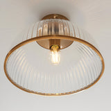 Langton Flush Downlight in brass with ribbed glass dome shade and exposed E27 bulb, mounted close to a white ceiling.