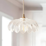 Ashwick clear glass pendant shade with scalloped edge and brass fitting, shown hanging in a bright kitchen setting.