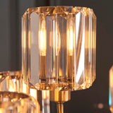 Close-up of the Clementine 9 Light Tiered Chandelier, showing faceted glass shades with antique brass fittings and lit E14 bulbs.