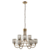 Clementine 9 Light Tiered Chandelier in antique brass with faceted glass shades on two tiers, hung from a chain, plain white background.