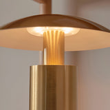 Close-up of the Cranbourne LED Table Lamp in brushed brass, showing the mushroom-style dome shade lit warm white above the cylindrical base.