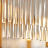 Close-up of the Endon Chatsworth 5 Light Pendant showing clear suspended glass rods in a double layer, lit by warm antique brass lamps.