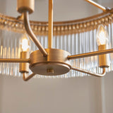Close-up of the Endon Chatsworth 5 Light Pendant in antique brass, showing the hub, curved arms, and double layer of clear glass rods with lit E14 bulbs.