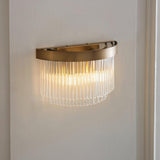 Chatsworth 2 Light Wall Light in antique brass, half-moon fitting with cascading clear glass rods, mounted on a white wall in a hallway setting.