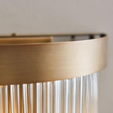 Close-up of the Chatsworth 2 Light Wall Light in antique brass, showing the brushed metal band and hanging clear glass rods.