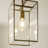 Endon Haddon Grand Pendant in brushed aged brass with clear glass panels and an exposed E27 filament bulb, shown lit against a neutral interior.