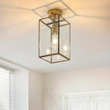 Endon Haddon flush ceiling light in aged brass with a rectangular glass lantern shade and single E27 bulb, mounted on a hallway ceiling.