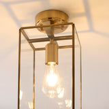 Endon Haddon flush ceiling light in aged brass with a rectangular glass shade and single E27 filament bulb, mounted to a white ceiling.