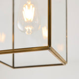 Close-up of the Endon Haddon flush ceiling light in aged brass, showing the mitred corner of the rectangular glass frame and E27 bulb within.