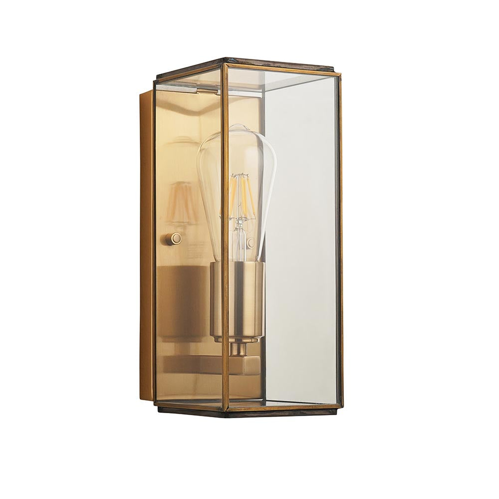 Haddon Wall Light in Antique Brass, a box-lantern design with clear glass panels and an exposed filament bulb, shown on a plain white background.