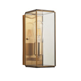 Haddon Wall Light in Antique Brass, a box-lantern design with clear glass panels and an exposed filament bulb, shown on a plain white background.