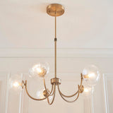 Bramwick 5 Light Pendant in antique brass with curved arms and clear twisted glass globes, shown suspended from a panelled ceiling on an adjustable stem.