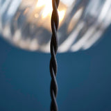 Close-up of the Endon Georgiana cascade pendant's black twisted fabric cable with a spiral glass shade and warm bulb glow softly blurred above.