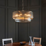 Endon Rothbury 8 light tiered chandelier in antique brass with clear ribbed glass panels, hung above a wooden dining table against dark panelled walls.