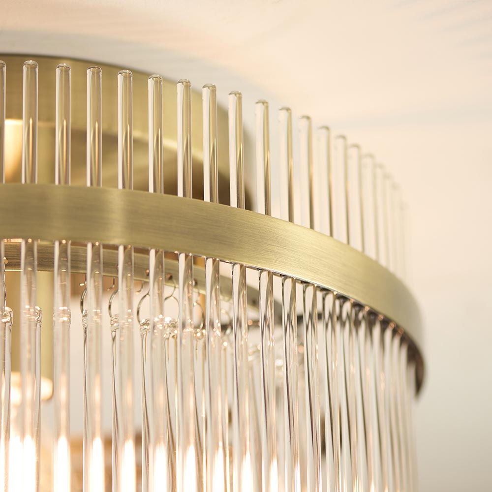 Close-up of the Endon Beaumont flush ceiling light showing its antique brass band and vertical clear glass rod shade.