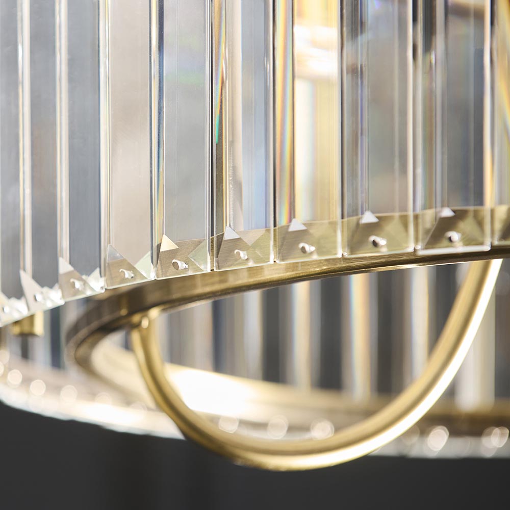 Close-up of the Fairfax 3 Light Semi-Flush Ceiling Light in antique brass, showing clear glass rods on a curved brass frame with faceted metal caps.