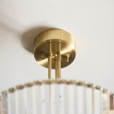 Fairfax 3 Light Semi-Flush Ceiling Light in antique brass, close-up of the round ceiling mount and rods above fluted glass shades against a plain white ceiling.