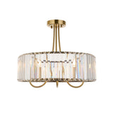 Fairfax 3-light semi-flush ceiling light in antique brass, round drum frame with clear crystal glass panels, shown on a plain white background.