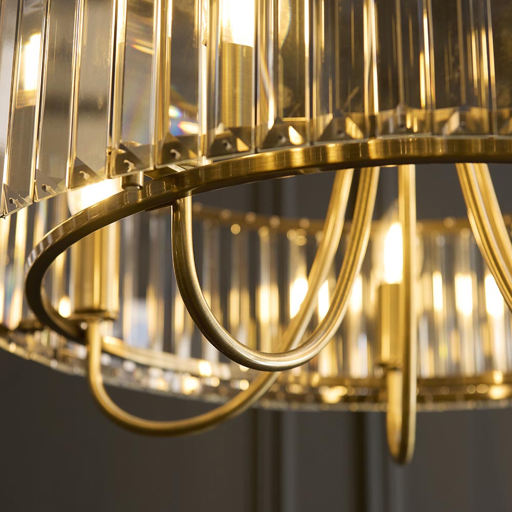 Close-up of the Fairfax 5 Light Pendant in antique brass, showing curved metal arms and faceted glass rods around the frame.