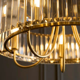 Close-up of the Fairfax 5 Light Pendant in antique brass, showing curved metal arms and faceted glass rods around the frame.