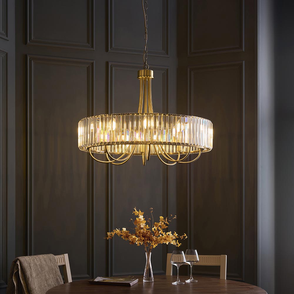 Endon Fairfax 8 Light Pendant in antique brass with a circular tier of cut lozenge glass, suspended above a dining table in a panelled room.