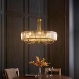 Endon Fairfax 8 Light Pendant in antique brass with a circular tier of cut lozenge glass, suspended above a dining table in a panelled room.