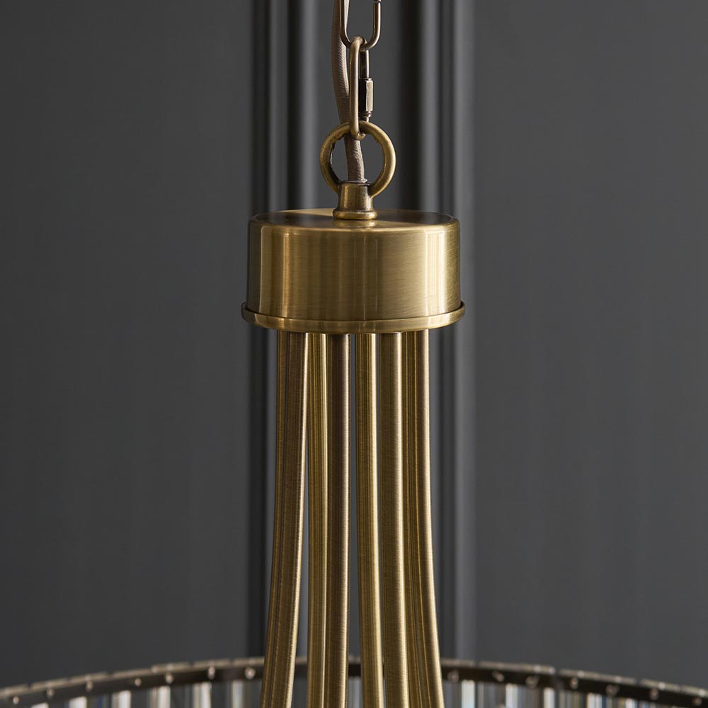 Close-up of the Endon Fairfax 8 Light Pendant showing the antique brass cap, chain loop and grey fabric cable against a dark grey background.