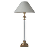 Aldmont Avalon table lamp with a clear glass column, antique brass base and cap, and a tapered natural linen shade, shown on a plain white background.