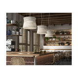 Syra 45 Aluminium LED Pendant Lights with woven ivory-white drum shades hanging at varying heights above a wooden bar counter in a rustic café setting.