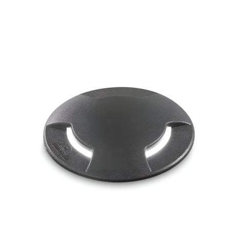 A round, black recessed light made from durable materials featuring a textured surface and curved grip design is presented on a white background, embodying the robustness associated with products like the Venus Outdoor Large Drive Over Recessed Light - Black.