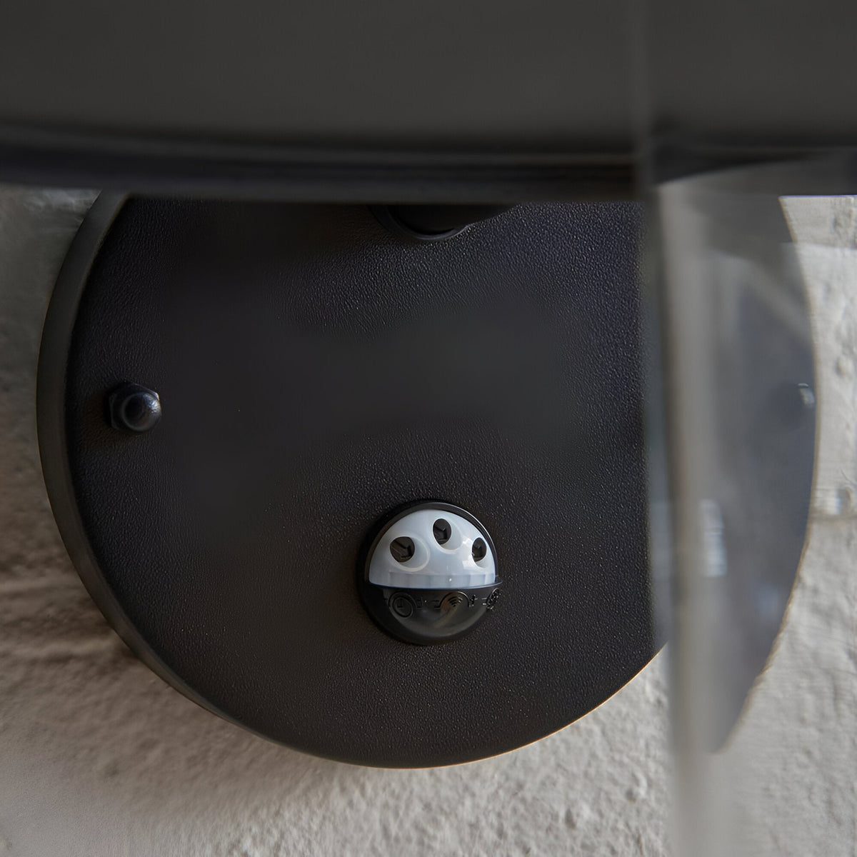 Close-up of the Endon Cranhurst outdoor wall light's matt black underside, showing the integrated PIR sensor and adjustment dials beneath the curved shade.