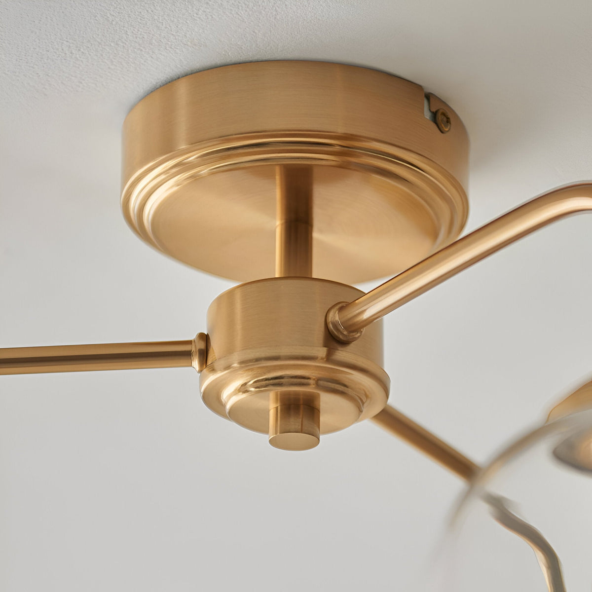 Close-up of the Halstead 3 Light Semi-Flush Ceiling Light in aged brass, showing the round ceiling mount, central column and branching arms in detail.