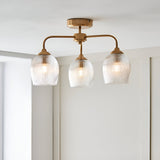 Endon Halstead Ribbed 3 light semi-flush ceiling light in aged brass with three ribbed glass shades on curved arms, shown installed against a white ceiling.