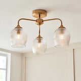 Endon Halstead Ribbed 3 light semi-flush ceiling light in aged brass with three ribbed glass shades on curved arms, shown on a white ceiling.